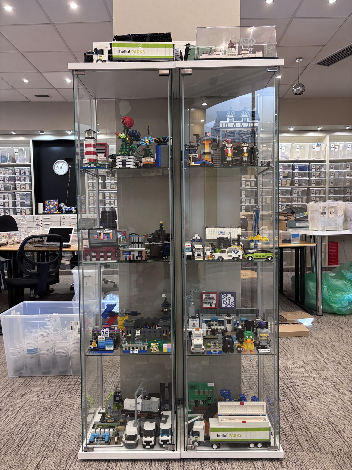 A glass cabinet full of finished custom brick builds made for clients