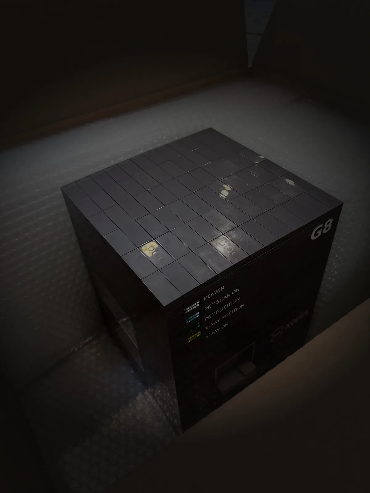A finished dark grey Xodus G8 build seated on bubble wrap inside its open shipping carton.