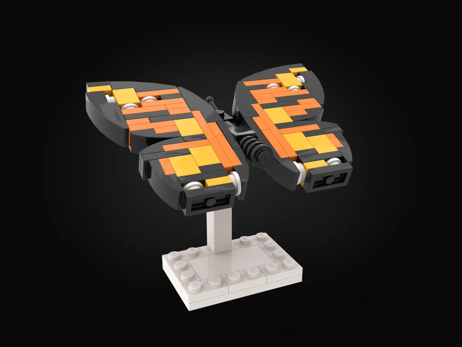 A butterfly built from LEGO® bricks, its orange, yellow and dark grey wings spread, mounted on a white stand.